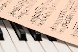Black and white piano keys with a sheet of classical music creating a harmonious composition.